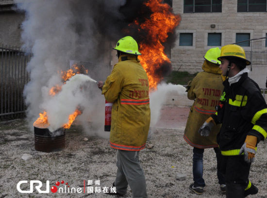 兩名志愿者在消防員的指揮下滅火。（攝影：張瑾） 