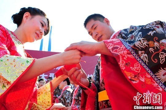 9月1日，一場別開生面的“重溫漢唐風”漢式集體婚禮在泉城濟南舉行，72名新人身著傳統漢服喜結良緣，并在許愿墻上許下“千年共枕眠，一世永相愛”心愿。圖為新人解纓結發。中新社發 張勇 攝