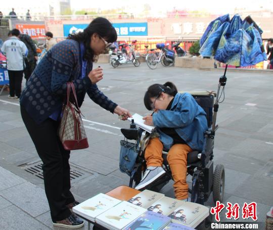 洛洛正在給買書的顧客簽名。 馮曉林 攝